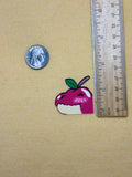 Small decorative item next to a penny and ruler on a beige background